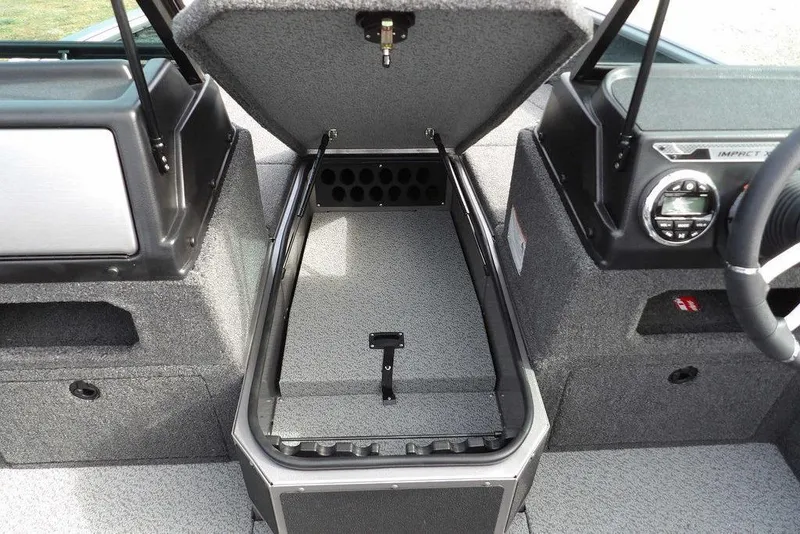 Slide: The Image of 2026 Lund 1875 Impact XS Sport boat storage compartment with open hatch and carpeted interior. - 38