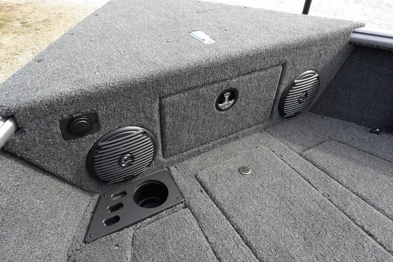 Slide: The Image of 2026 Lund 1875 Impact XS Sport boat storage compartment with rod holders and carpeted interior. - 42