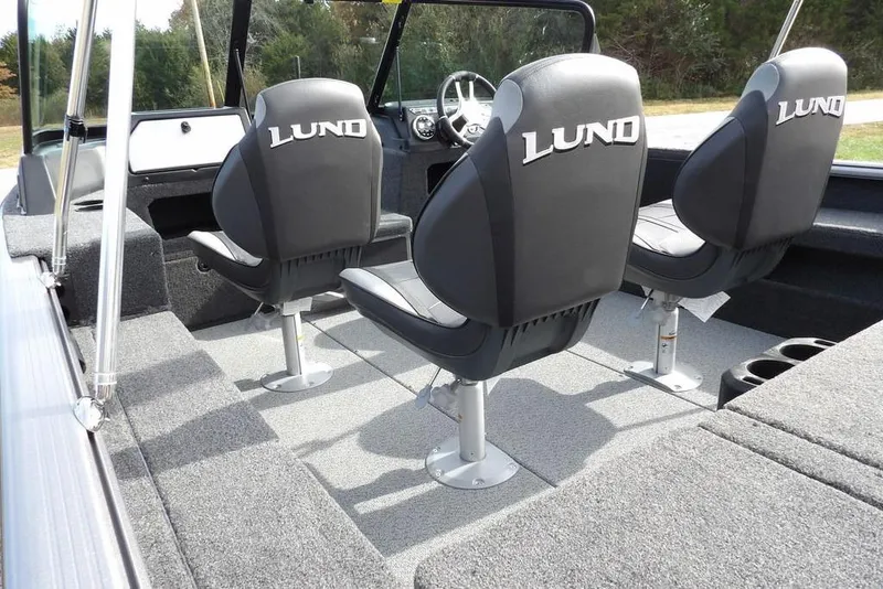 Slide: The Image of 2026 Lund 1875 Impact XS Sport boat interior with seating and motor, featuring gray upholstery. - 8