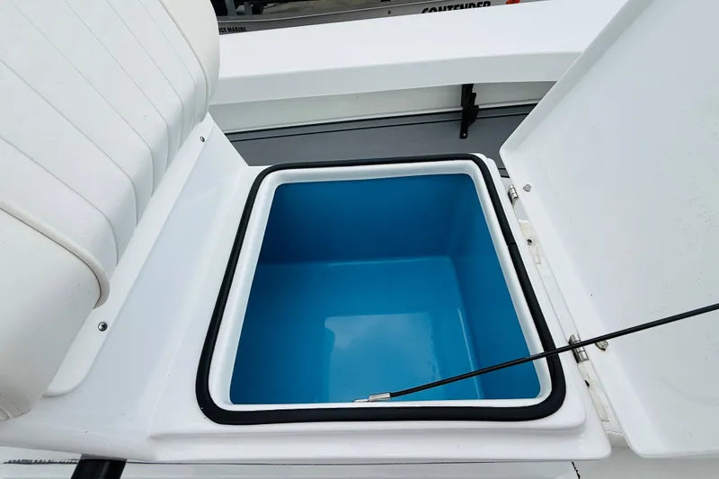 Slide: The Image of 2021 Beavertail Skiffs 18 Mosquito storage compartment with open lid, showcasing interior space. - 11