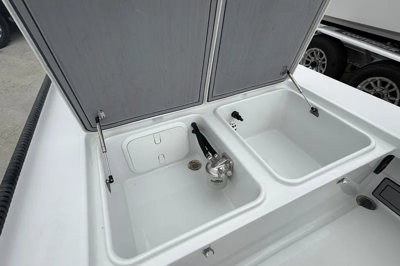 Slide: The Image of 2021 Beavertail Skiffs 18 Mosquito boat storage compartments with open lids and visible fittings. - 13