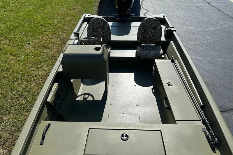 Slide: The Image of 2026 Lowe Roughneck 1860SC boat interior with two camo seats, steering console, and storage compartments. - 10