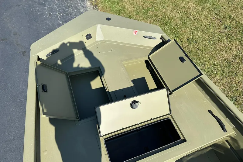 Slide: The Image of 2026 Lowe Roughneck 1860SC boat with open storage compartments on a sunny day. - 11