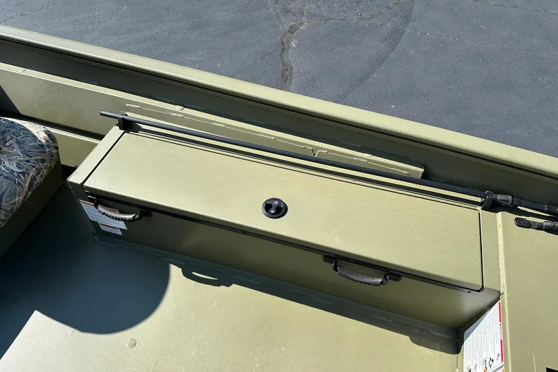 Slide: The Image of 2026 Lowe Roughneck 1860SC boat interior with storage compartment and camouflage seat. - 13