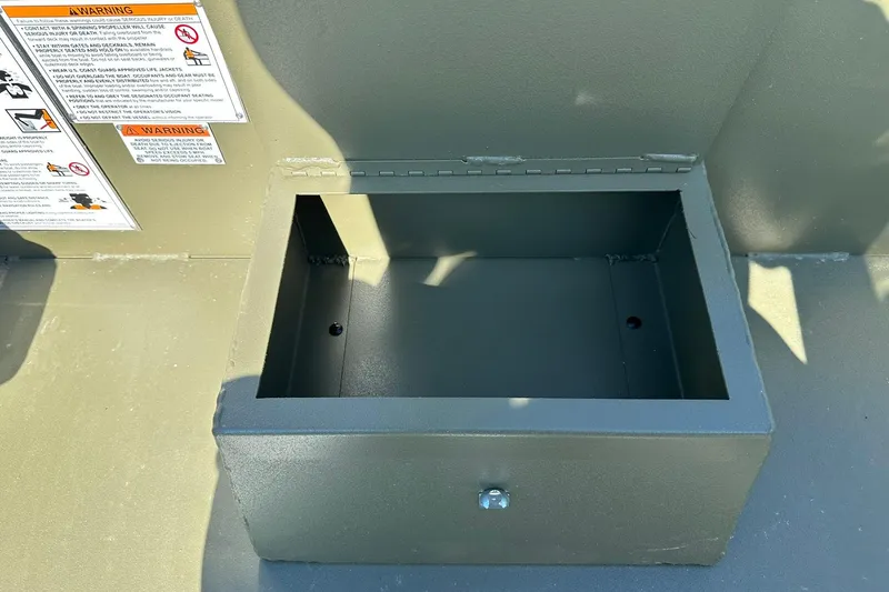 Slide: The Image of Open storage compartment on 2026 Lowe Roughneck 1860SC boat with warning labels. - 21