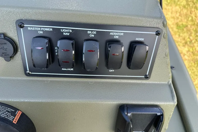 Slide: The Image of Control panel of 2026 Lowe Roughneck 1860SC boat with switches for power, lights, bilge, aerator, and horn. - 22