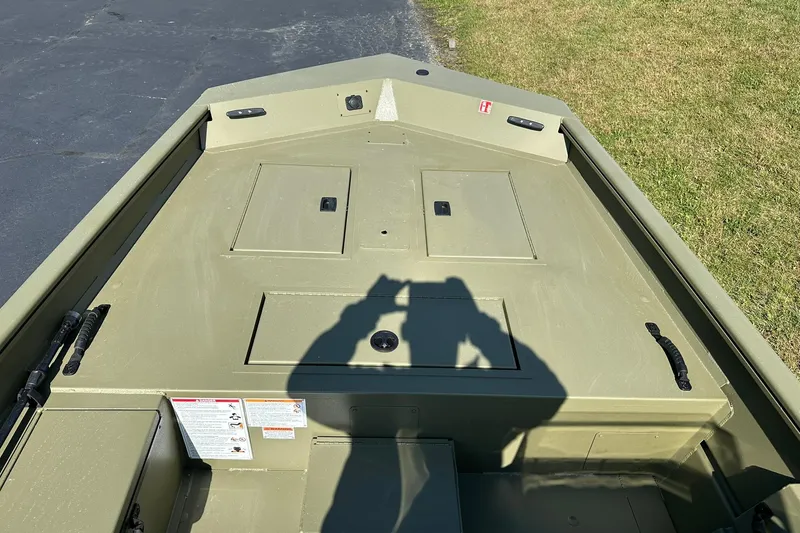 Slide: The Image of 2026 Lowe Roughneck 1860SC boat interior with storage compartments, photographed outdoors. - 8