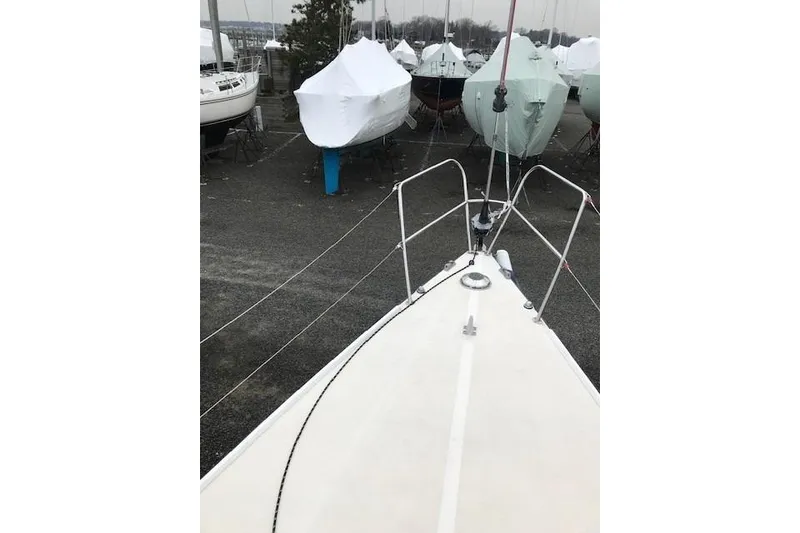 Slide: The Image of 1997 JBoat J 105 sailboat in storage, surrounded by covered boats. - 12