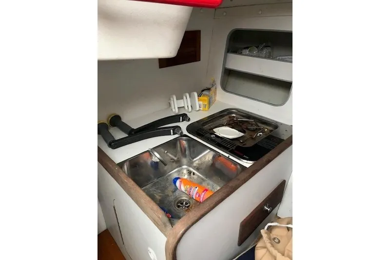 Slide: The Image of 1997 JBoat J 105 galley with sink, stove, and storage shelves. - 22