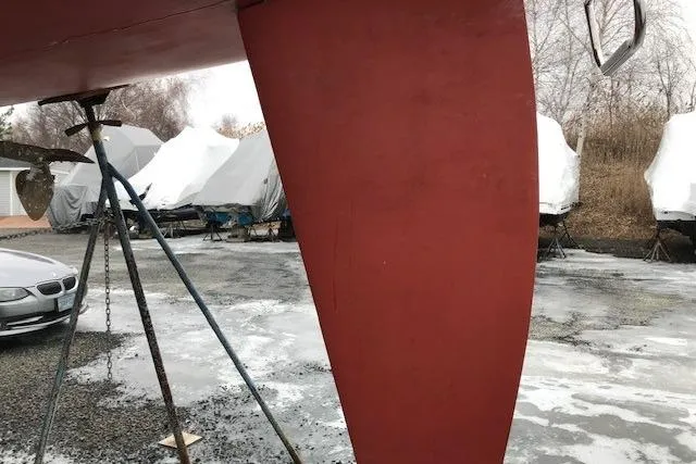 Slide: The Image of Red keel of a 1997 JBoat J 105 in a boatyard with covered boats. - 27