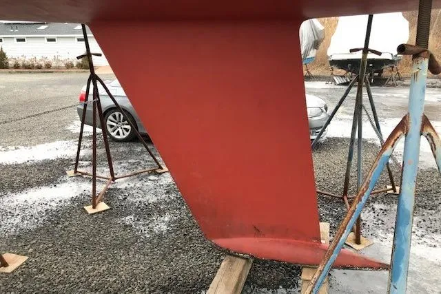 Slide: The Image of Red keel of a 1997 JBoat J 105 sailboat on stands in a gravel yard. - 28