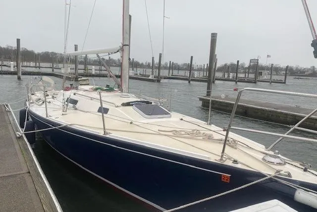 Slide: The Image of 1997 JBoat J 105 sailboat docked in a marina on a cloudy day. - 5