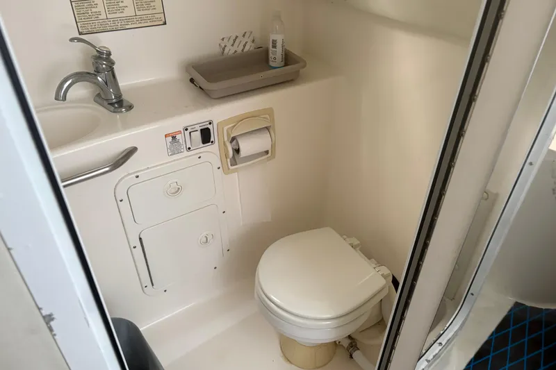 Slide: The Image of 2004 Century 3200 WA boat bathroom with toilet, sink, and storage compartments. - 1