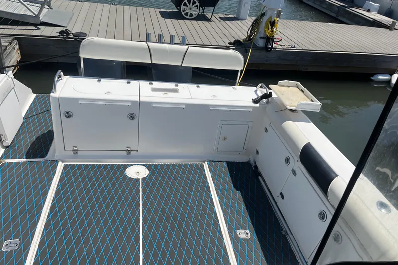 Slide: The Image of 2002 Century 3200 Walk-Around boat interior with seating and storage at dock. - 17