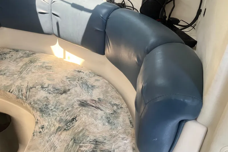 Slide: The Image of 2002 Century 3200 Walk-Around boat interior with blue cushioned seating and patterned upholstery. - 23