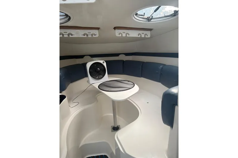 Slide: The Image of 2004 Century 3200 WA cabin interior with seating, table, and fan. - 2