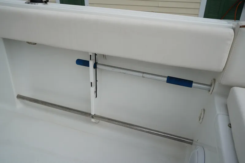 Slide: The Image of 2022 Sea Hunt Ultra 229 boat interior detail with rod holder and cushioned seating. - 10