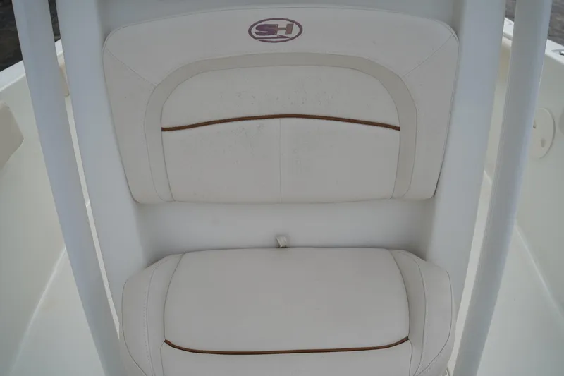 Slide: The Image of 2022 Sea Hunt Ultra 229 boat seat with white upholstery and logo. - 22
