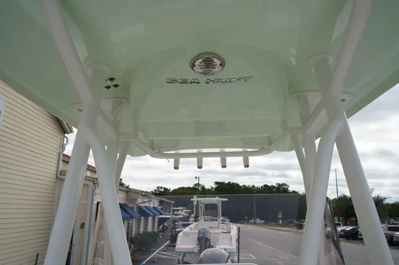 Slide: The Image of 2022 Sea Hunt Ultra 229 boat with T-top, parked outdoors. - 23