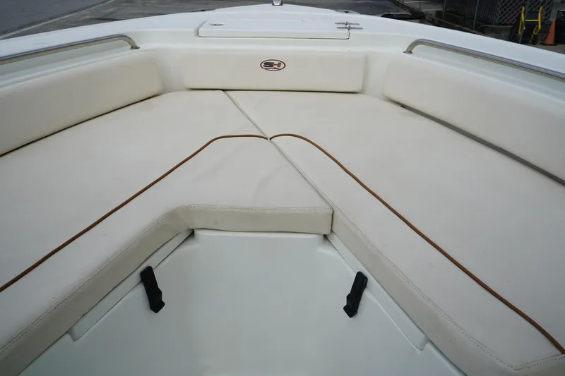 Slide: The Image of 2022 Sea Hunt Ultra 229 boat interior with cushioned seating area. - 24