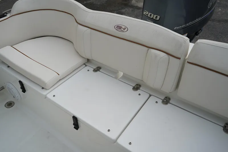 Slide: The Image of 2022 Sea Hunt Ultra 229 boat interior with white cushioned seating and Yamaha engine. - 7