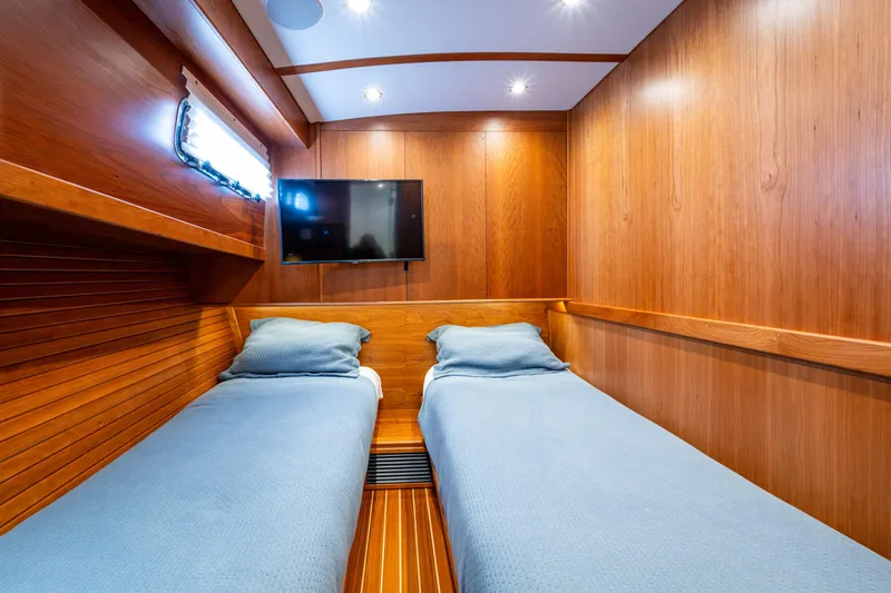 Slide: The Image of 2022 Sabre 58 Salon Express cabin with twin beds, wood paneling, and wall-mounted TV. - 25