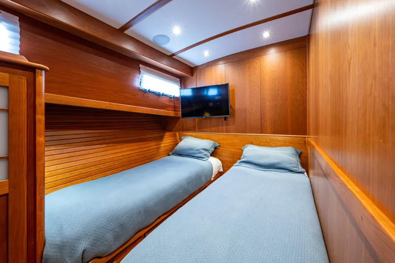 Slide: The Image of 2022 Sabre 58 Salon Express cabin with twin beds, wood paneling, and wall-mounted TV. - 26