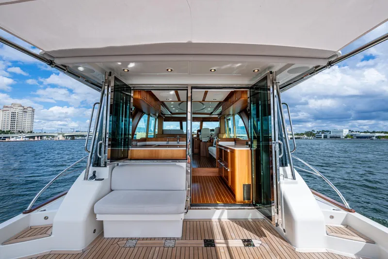 Slide: The Image of 2022 Sabre 58 Salon Express yacht interior with open glass doors, overlooking water. - 3