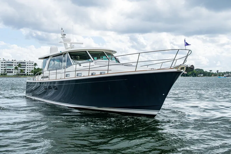 Slide: The Image of 2022 Sabre 58 Salon Express yacht cruising on a calm waterway under cloudy skies. - 42