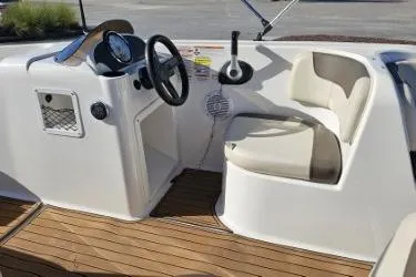 Slide: The Image of 2019 Bayliner Element E18 boat interior with steering console and seating. - 1