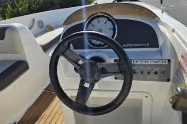 Slide: The Image of 2019 Bayliner Element E18 boat dashboard with steering wheel and instrument panel. - 20