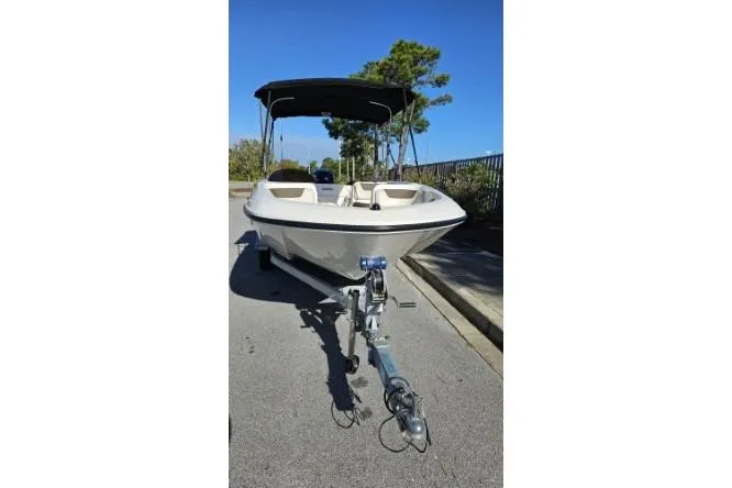 Slide: The Image of 2019 Bayliner Element E18 boat on trailer, parked on a sunny street. - 22