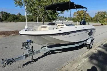 Slide: The Image of 2019 Bayliner Element E18 boat on trailer, parked outdoors with canopy. - 8