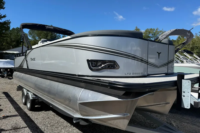 The Image of 2026 Tahoe Pontoon LTZ Entertainer boat on trailer, sleek design, outdoor setting. - 0