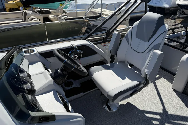 Slide: The Image of 2026 Tahoe Pontoon LTZ Entertainer boat interior with captain's chair and steering console. - 10