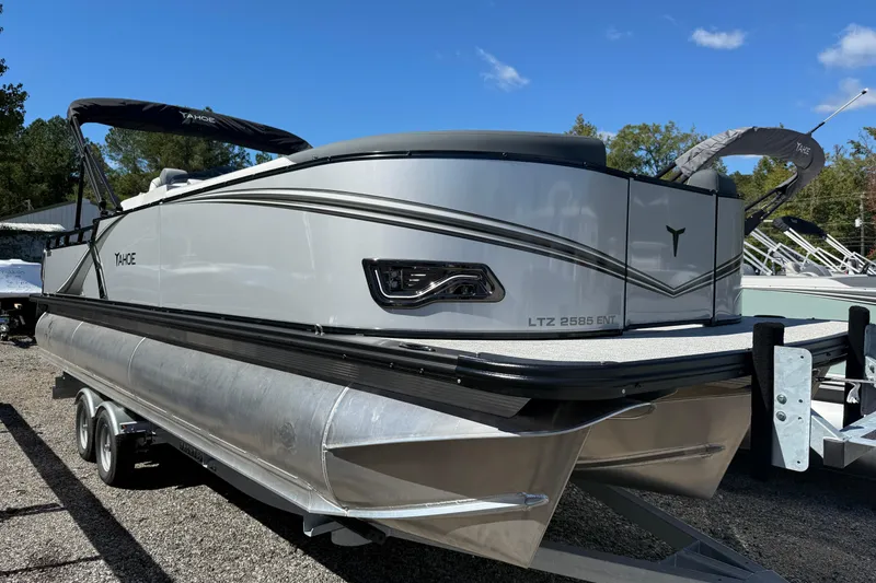 Slide: The Image of 2026 Tahoe Pontoon LTZ Entertainer boat on trailer, sleek design under clear blue sky. - 17