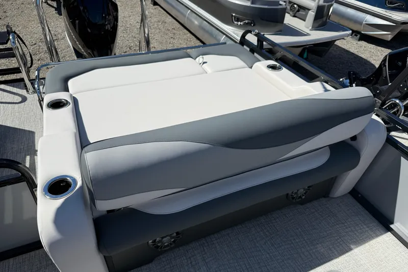 Slide: The Image of 2026 Tahoe Pontoon LTZ Entertainer boat seating with cup holders, gray and white upholstery. - 7