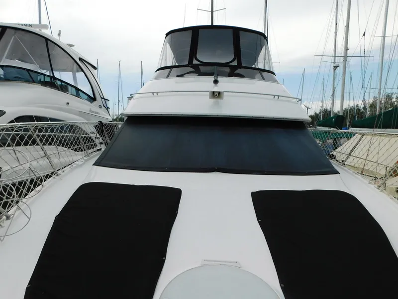 Slide: The Image of 2003 Carver 444 Cockpit Motor Yacht docked at marina, front view. - 12