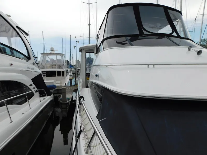 Slide: The Image of 2003 Carver 444 Cockpit Motor Yacht docked among other boats at a marina. - 14