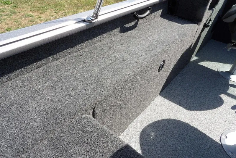 Slide: The Image of Interior view of 2026 Lund 1875 Impact XS Sport boat, featuring carpeted flooring and seating. - 18