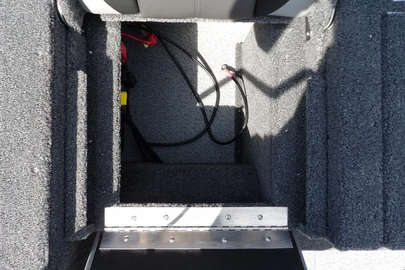 Slide: The Image of 2026 Lund 1875 Impact XS Sport boat interior storage compartment with carpeted finish. - 19