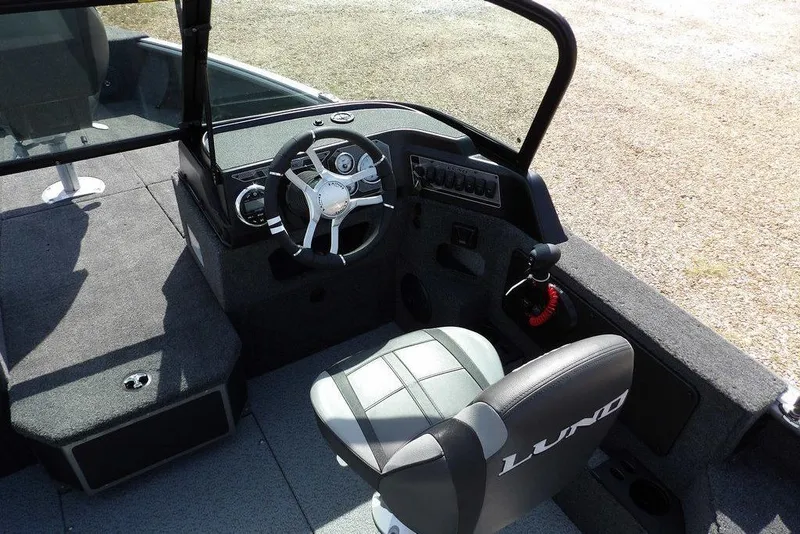 Slide: The Image of 2026 Lund 1875 Impact XS Sport boat interior with steering wheel and seating. - 22