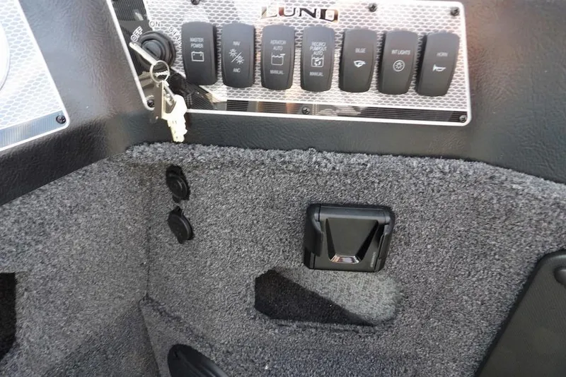 Slide: The Image of Control panel of 2026 Lund 1875 Impact XS Sport boat with switches and keys. - 23