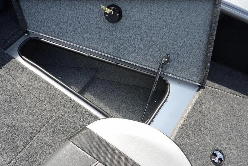 Slide: The Image of 2026 Lund 1875 Impact XS Sport boat storage compartment with open hatch and carpeted interior. - 37