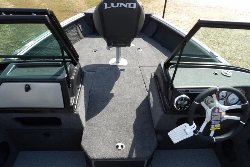 Slide: The Image of 2026 Lund 1875 Impact XS Sport boat interior with steering wheel and seating. - 38