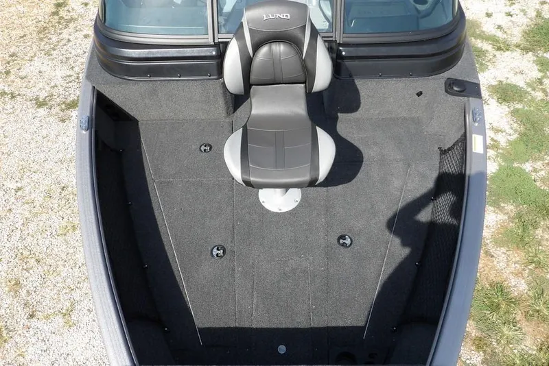Slide: The Image of 2026 Lund 1875 Impact XS Sport boat interior with single seat, gray carpet, and spacious layout. - 45