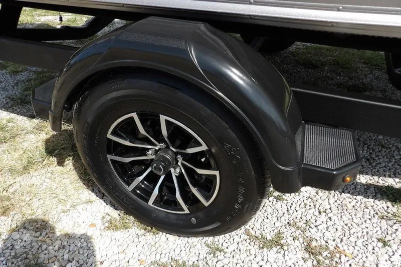 Slide: The Image of 2026 Lund 1875 Impact XS Sport trailer wheel on gravel surface. - 48