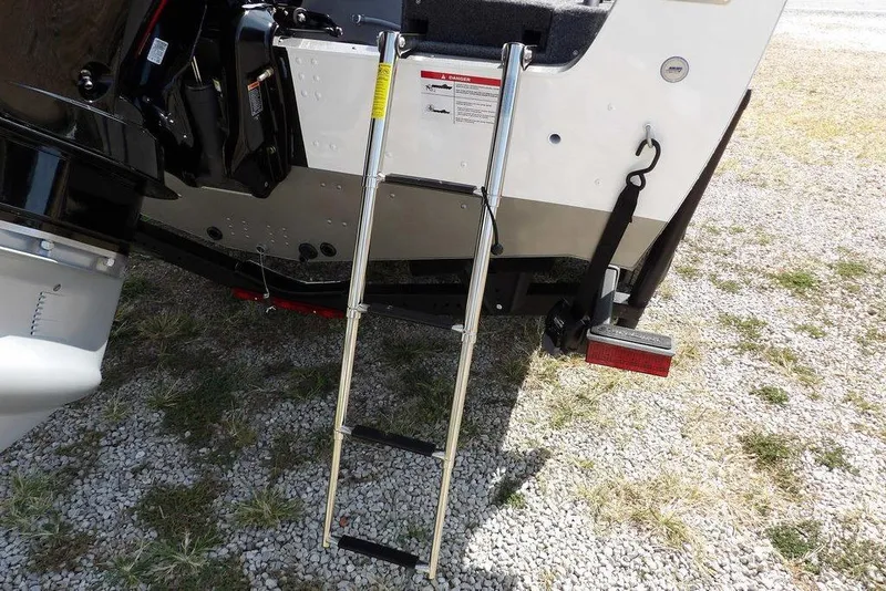 Slide: The Image of 2026 Lund 1875 Impact XS Sport boat ladder on gravel surface. - 55