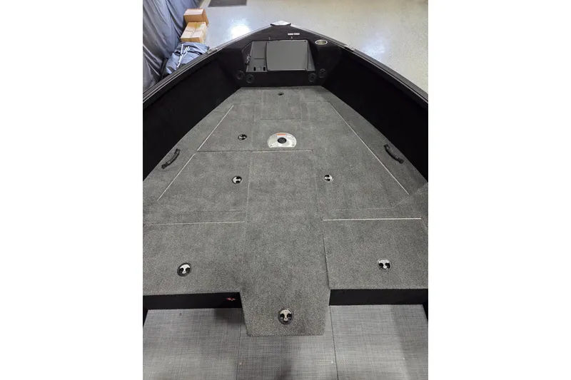 Slide: The Image of 2026 Alumacraft Competitor 185X Tiller boat interior with carpeted deck and storage compartments. - 3