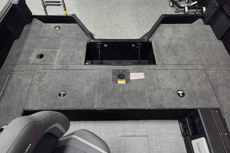 Slide: The Image of 2026 Alumacraft Competitor 185X Tiller boat interior with carpeted deck and storage compartments. - 8